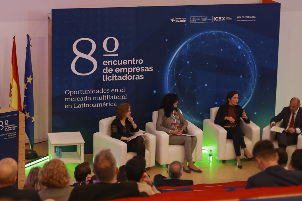 Ponentes en sofás hablando sobre oportunidades en el mercado multilateral en Latinoamérica.
